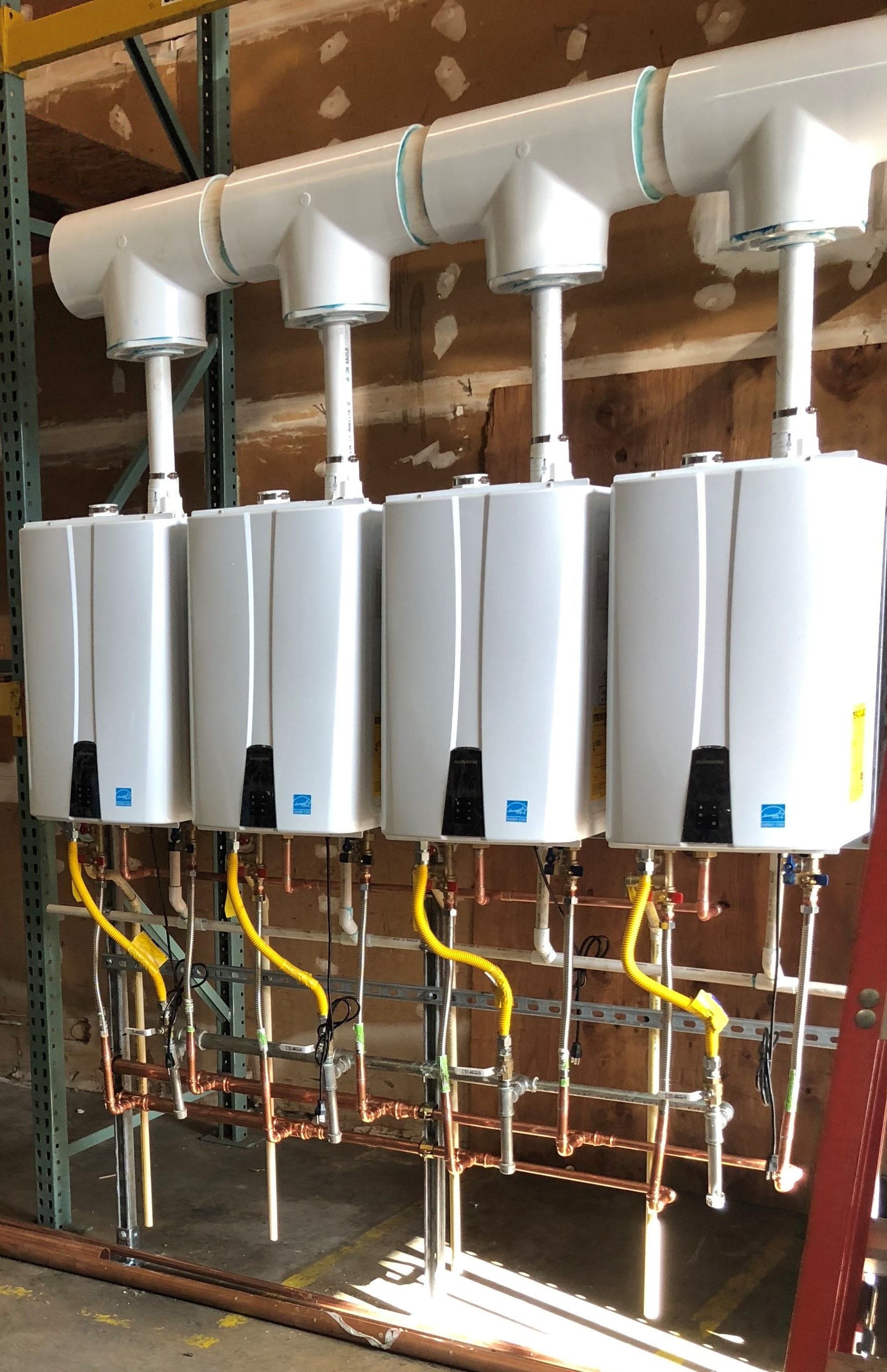 Four tankless water heaters in a row.